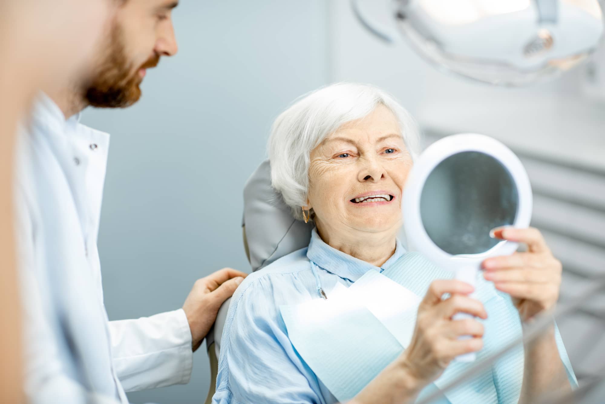 Patient examining a set of hybrid dentures.