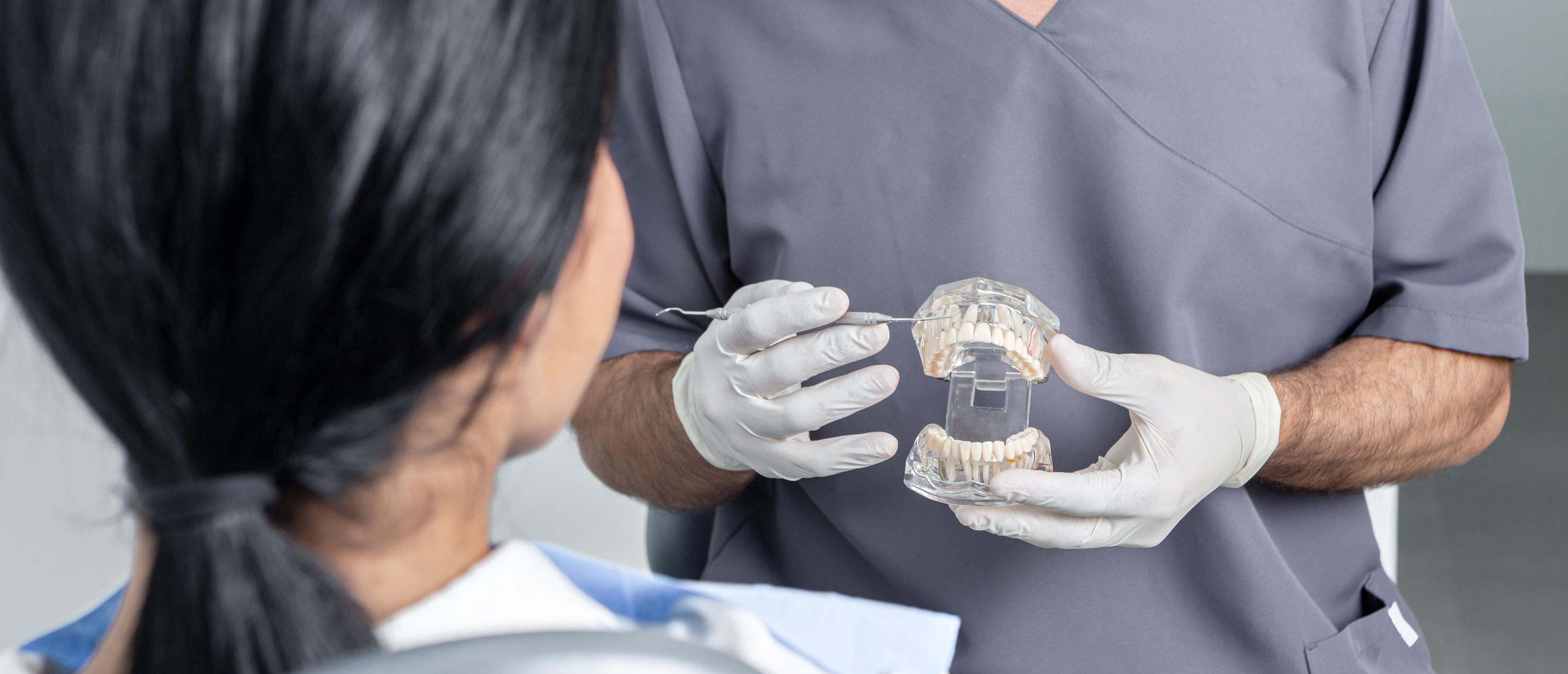 Dentist showing an opened dental mould to a patient in a dental clinic